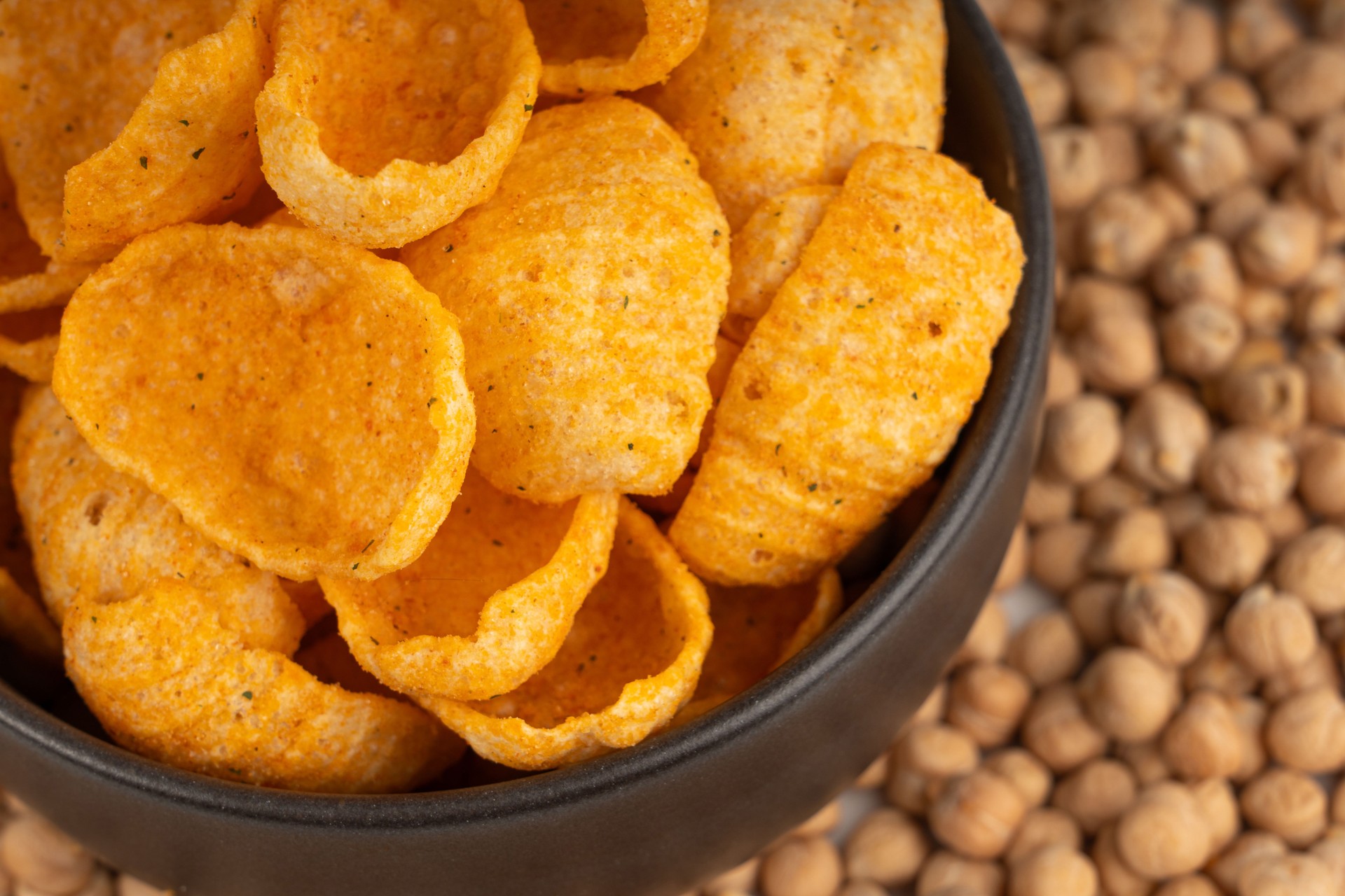 Hummus chickpea chips, chick pea crisps pile, healthy orange snack, fried legume crunchies